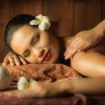 Masseur doing massage on Asian woman body in the spa salon
